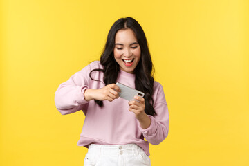People emotions, lifestyle leisure and beauty concept. Cheerful enthusiastic asian girl gamer...