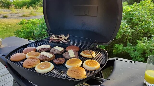 Homemade burgers on the grill with halloumi and buns