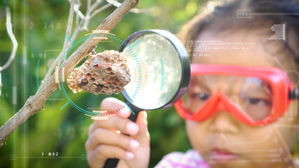 Asian little girl examining wasp's nest through a magnifying glasswith digitally generated...