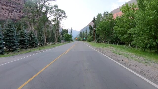 POV while driving on Highway 550 through Uncompahgre River valley  near Ouray Colorado; passing Rotary Park and a sign warning to watch for wildlife