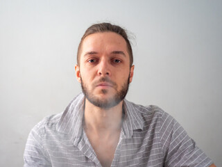 Obraz premium Caucasian Male in Grey Shirt Smoking Legal Cannabis Joint Blows Down Happily