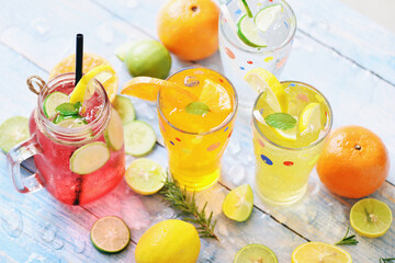 Exotic summer drinks refreshing variety of cold drinks glasses fresh fruit and vegetable on ice homemade cocktail tea with mojito lemon lime orange rosemary and cucumber, Colorful summer drink juicy