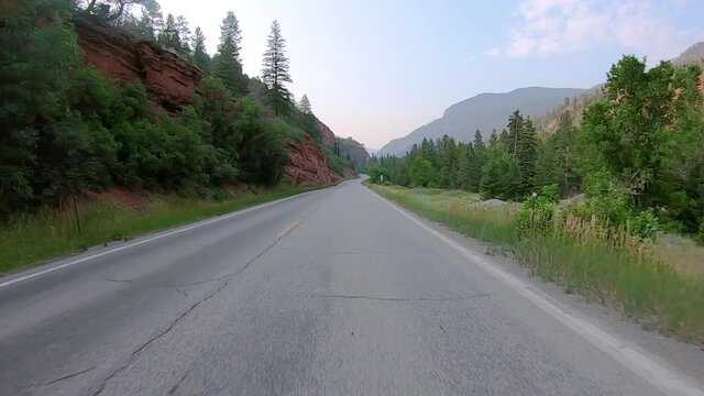 POV while driving on Highway 550 through Uncompahgre River valley  near Ouray Colorado; views of red cliffs and San Juan Mountains