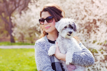 Beautiful Young Woman Hugging  her White Havanese  Dog Outdoor in the Spring Park .Pet and Owner Outdoor 