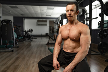 Fototapeta na wymiar Portrait of a senior muscular man in a gym