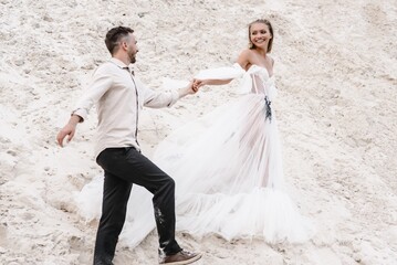 Beautiful wedding couple bride and groom at wedding day outdoors at ocean beach. Happy marriage couple o