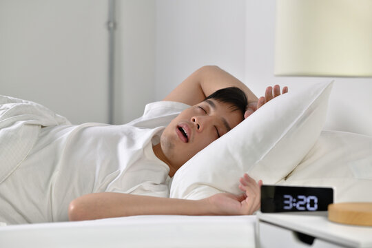  Young Asian Man Sleeping And Snoring Loudly Lying In The Bed.