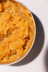 Body scrub of oatmeal, sugar, honey and oil in melat eco jar on white table, homemade cosmetic for peeling and spa care
