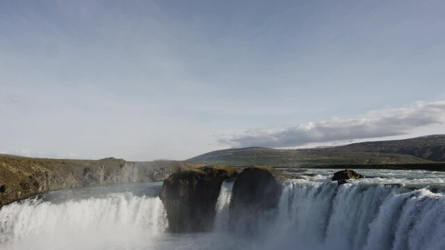Wide panoramic tilt down to reveal clip of the Godafoss Waterfalls in Iceland - Nature, adventure and majesty concepts.