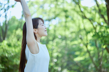 森の中でリラックスする若い日本人女性