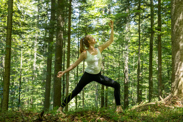 Woman practicing yoga in the forest