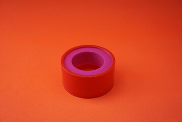 Stock photo of insulation or orange colored plaster in a circle. Isolated on an orange background. Stationery and office industry, design, website photos.