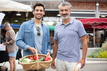 friends with baskets of produce at farmers market