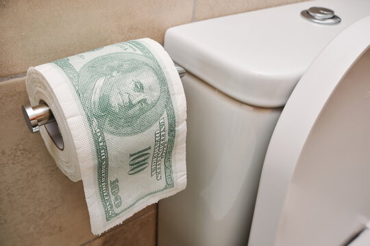 Toilet roll with US dollar bill printed - senseless wasting money financial crisis concept