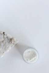 Moisturizing cosmetic cream stands on neutral background with milk splash