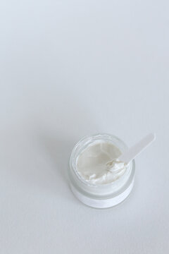 Moisturizing Cosmetic Cream With Eucalyptus Stands On Neutral Background With Milk Splash