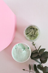 Moisturizing cosmetic cream with eucalyptus stands on neutral background with milk splash