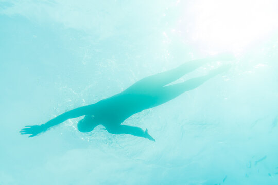 Silhouette Of An Athlete Swimming In Beautiful Blue Water