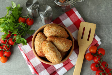 Concept of tasty food with cutlets on gray textured table