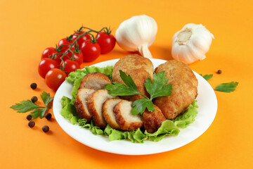 Concept of tasty food with cutlets on orange background
