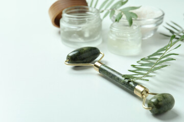 Skin care concept with face roller on white background