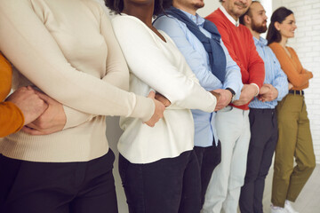 Group of diverse people showing unity and support. Cropped indoor shot of team of happy multi...