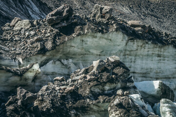 Nature background with icefall near glacier wall with cracks and scratches. Natural backdrop with icy wall and blocks of ice. Beautiful landscape with shiny glacial wall and ice blocks in sunlight.
