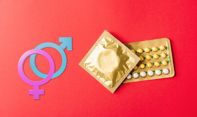 World sexual health or Aids day. Male, female gender signs condom on wrapper pack and contraceptive...