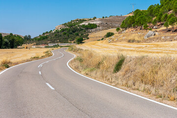 empty road with curves crossing fields of crops