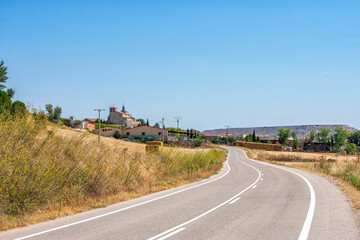 empty road with curves crossing fields of crops