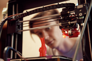 Young male looking at 3D printer