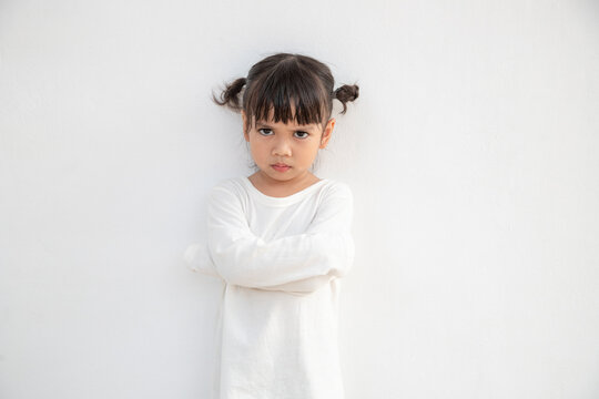 Angry little girl over white background, sign and gesture concept