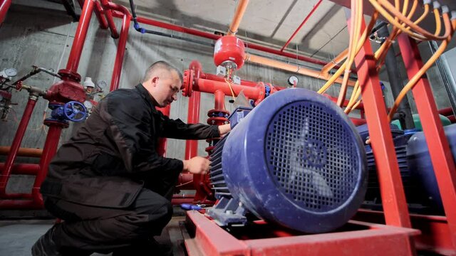 A water pumping station engineer repairs the water supply compressor engine.