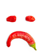 Sad smile from Habanero and Rezha peppers. Facial image made of hot red pepper isolated on white background.
