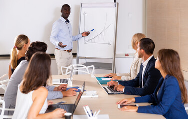 Obraz premium Confident African American businessman presenting new business project to coworkers