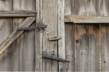 The old village gate.A fragment of an old wooden gate closed with an ancient bolt.