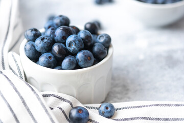 Organic fresh farm big macro blueberry in a white ceramic bowl breakfast mood. Food photography in a high key, light colors. Natural vegetarian dessert.