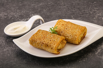 Staffed pancakes served sour cream