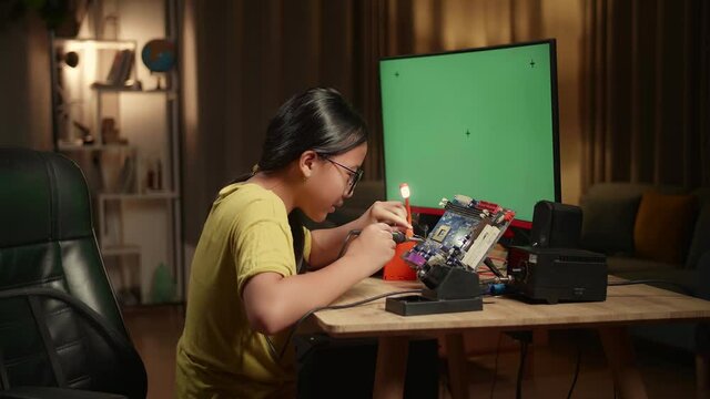 It Girl Is Soldering Electronic Circuit And Works With Computer In Home, Mock Up Green Screen Display, Genius Children Concept

