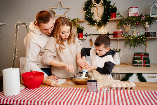 little boy pours milk himself. family together prepares dishes for the new year