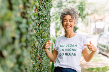 Cheerful vegan activist advocating for veganism outdoors - obrazy, fototapety, plakaty