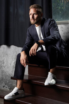 man in suit sitting on stairs