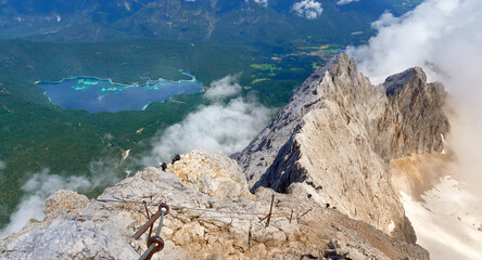 Höllental via ferrata to Zugspitze, top of Germany with climbers and famous Eibsee in the background