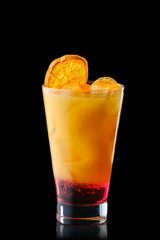 Cold refreching cocktail with orange juice and cherry syrup isolated on black