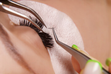 Eyelash Extension Procedure. Woman Eye with Long Eyelashes. Close up, selective focus. - 450025392