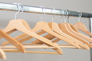Wooden hangers on a metal bar. Free hangers for clothes in the dressing room