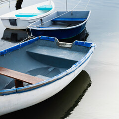 Fototapeta na wymiar Three boats in the bay. Abstract geometry of empty dinghies on the blue seawater.