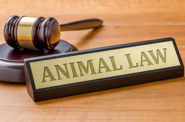 A gavel and a name plate with the engraving Animal law