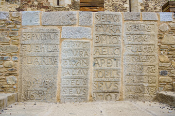 Llivia, Spain. Old granite stone tombstones on a wall. 