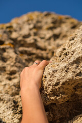 Female hand climbing a rock